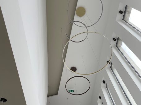 Hängende Ringe an der Decke eines modernen Raumes mit großen Fenstern.