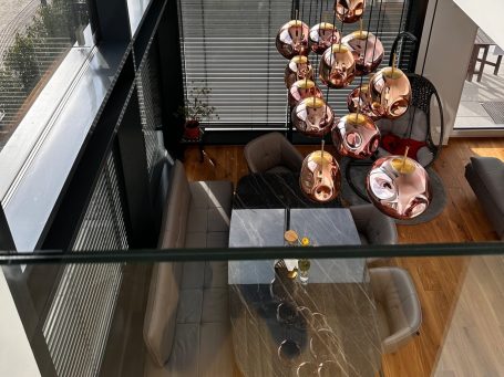 Moderne Wohnung mit einem eleganten Esstisch und Designer-Hängelampen.